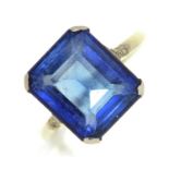 A synthetic sapphire ring, with diamond shoulders, in platinum coloured metal, 3.2g, size K½ Good