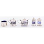 A George V three piece pierced silver condiment set, blue glass liner, pepperette 50mm h, by E