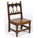 An oak chair, 17th c and later, the arcaded back with acorn and scroll finials, applied split