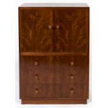 A Gordon Russell walnut cabinet, c1935, enclosed by a pair of doors in matched veneers above three
