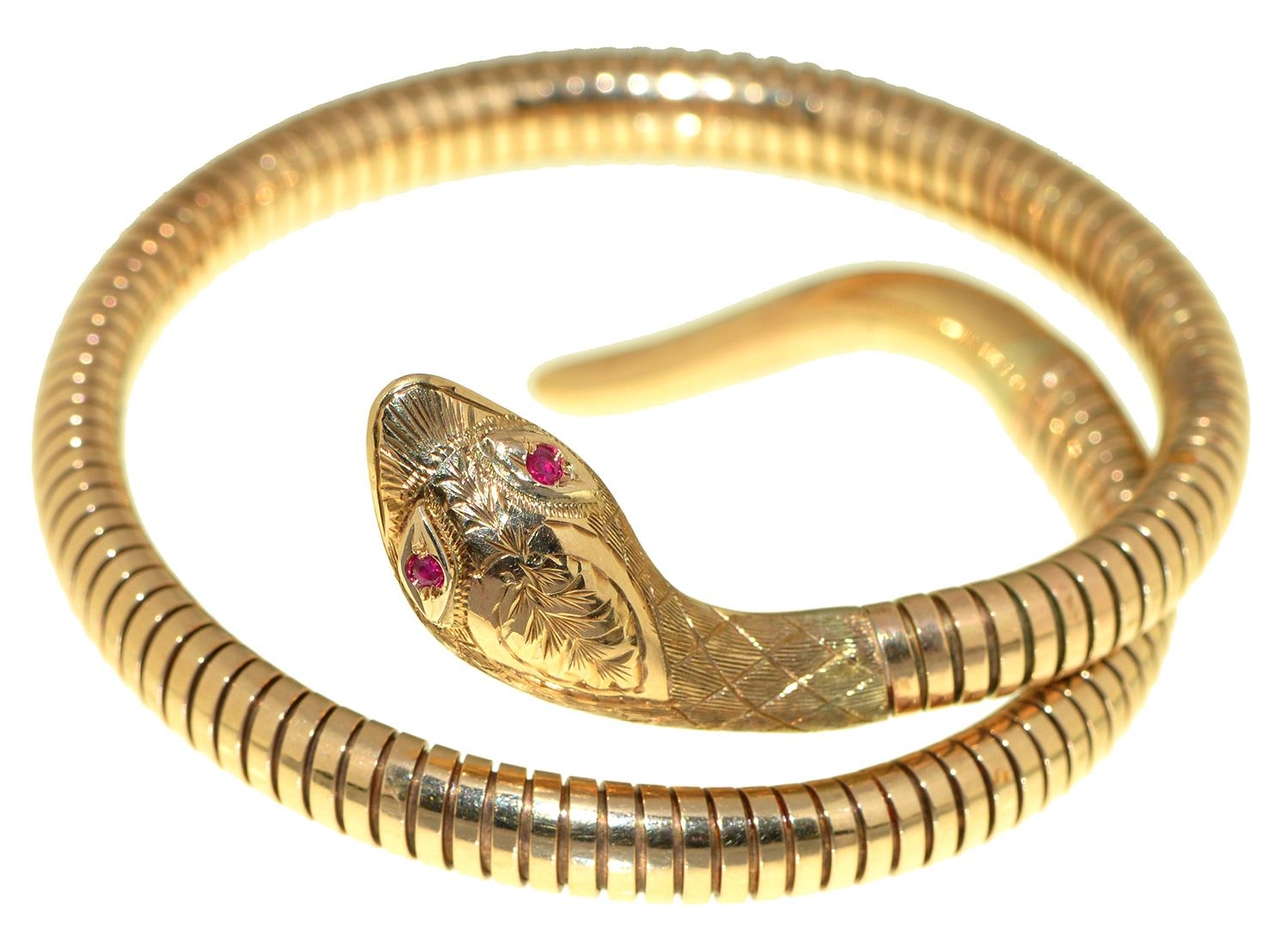 A 9ct gold serpent bracelet with ruby eyes, approximately 63mm, maker C & F (incuse), Chester 1960