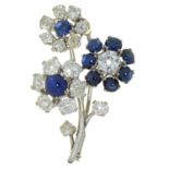 A diamond and sapphire three flower brooch, of old cut diamonds and cabochon sapphires, in white