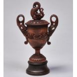 An Indian carved wood cup and cover, shield shaped with mythical beast finial, on associated
