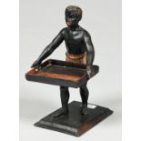 A carved and painted wood negro figural card tray, late 19th c, with glass eyes, the rectangular