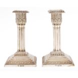 A pair of Edward VII silver dwarf cluster columnar candlesticks, on stepped square foot, nozzles,