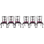 A set of six Edwardian ebonised mahogany dining chairs, with carved splat, on cabriole legs and claw