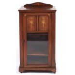 An Edwardian rosewood and inlaid music cabinet, with shell paterae, the partly glazed door with
