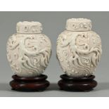 A pair of Chinese white glazed porcelain tea caddies and covers, applied with squid and waves over
