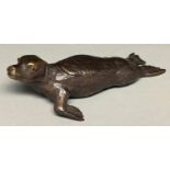 A bronze seal novelty inkwell, c1900, with glass eyes, brown patina, detachable brass well, 17cm l