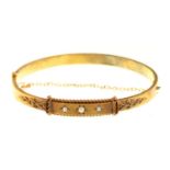 An Edwardian gold bangle, gipsy set with three split pearls, 61mm, unmarked, 9.4g, cased Slightly