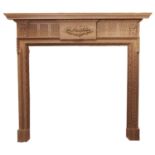 A neo classical style pine chimneypiece, second half 20th c, with crisply carved floral tablet and