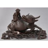 A Chinese rootwood carving of a boy on a buffalo, late 19th c, with glass eyes and bone teeth and