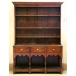 An oak dresser, 19th c, the rack and baes with boarded or panelled back respectively, having ovolo