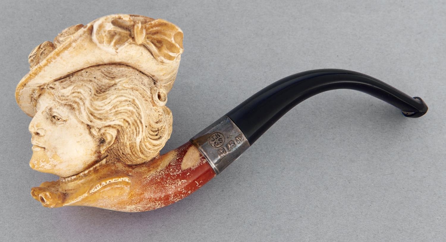 A meerschaum tobacco pipe, early 20th c, the bowl carved with the head of a lady of fashion in a