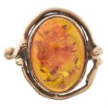 An amber ring, in gold, apparently unmarked, 5.9g, size H Slight wear scratches