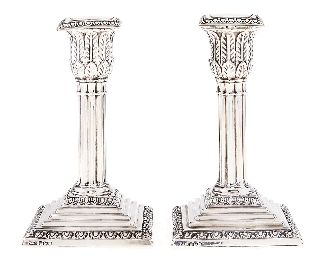 A pair of Edward VII silver dwarf cluster columnar candlesticks, on stepped square foot, nozzles,