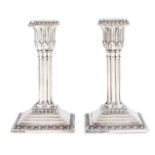 A pair of Edward VII silver dwarf cluster columnar candlesticks, on stepped square foot, nozzles,