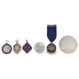 Three silver watch fob medallions, a similar badge, a commemorative silver medal and a silver yes/no