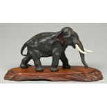 A Japanese bronze sculpture of an elephant, Meiji period, even black patina, the ears russet,