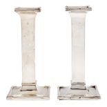 A pair of George V silver candlesticks, of plain square design on flared foot, nozzles, 15.5cm h,