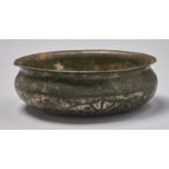 An Islamic tinned copper bowl, 17th c, of compressed form with everted rim and pricked