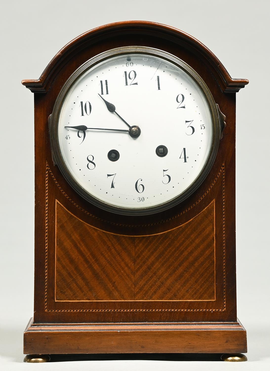 A mahogany and broken line inlaid breakarched mantel clock, c1920, with enamel dial, gong striking