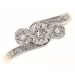 A three stone diamond crossover ring, illusion set, gold hoop marked 18ct PLAT, 2.3g, size K½