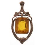 A shield shaped gold openwork pendant, with central articulated yellow paste, early 20c, marked 9xt,