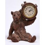 A Swiss carved limewood bear novelty timepiece, c1900, the seated bear supporting on its left