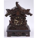 A German carved and stained softwood chalet form cuckoo clock, c1900, with bone hands and wire gong,