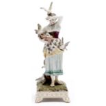 A German porcelain figure of a young women feeding pigeons, 20th c, on square base, 32cm h Bird on