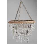 A chandelier, the gilt lacquered brass leafy corona above three graduated tiers of prismatic cut