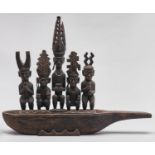 An African hardwood carving modelled as a boat, the interior with five squatting and standing