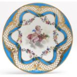 A French porcelain saucer, 19th c, in Sevres style, painted with an amorini and flowers in bleu