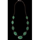 A gold necklace,  with nine oval Chinese carved and pierced jadeite panels, 53cm l, marked on