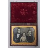 A quarter plate daguerreotype of a family, c1850, in embossed maroon leather case
