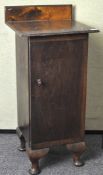 A early 20th century Oak pot cupboard raised upon stubbed cabriolet legs,