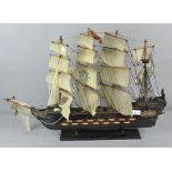 A vintage three masted wooden model of a sailing boat on stand,