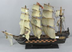 A vintage three masted wooden model of a sailing boat on stand,