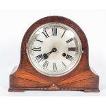 A German (Kienzle) Art Deco oak cased mantle clock, the silvered dial and black numerals,