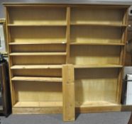 A large double pine bookcase raised on plinth, having nine shelves. Measures; 207cm x 220cm x 24cm.