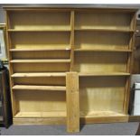 A large double pine bookcase raised on plinth, having nine shelves. Measures; 207cm x 220cm x 24cm.