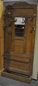 An oak five panel hall stand, with central mirror and stick stand,