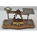 A set of vintage letter scales and weights, mounted to a shaped oak base with ivorine plaque to top,