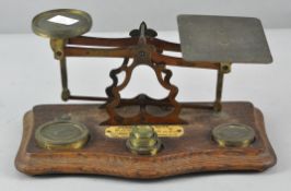 A set of vintage letter scales and weights, mounted to a shaped oak base with ivorine plaque to top,