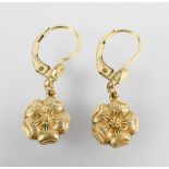 A yellow metal pair of drop earrings of floral design. Stamped 14ct.ro. Tests indicate gold plated.