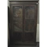 A mahogany veneered two door bookcase with solid panel base with two glazed sections above,