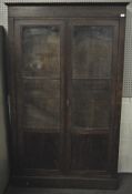 A mahogany veneered two door bookcase with solid panel base with two glazed sections above,