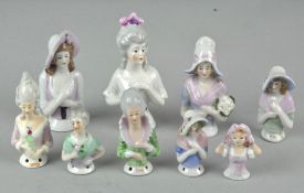 A collection of assorted ceramic pin cushion ladies, largest 9cm high,
