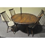 A mid century vintage Ercol beech and elm drop leaf table of oval form with four matching chairs,